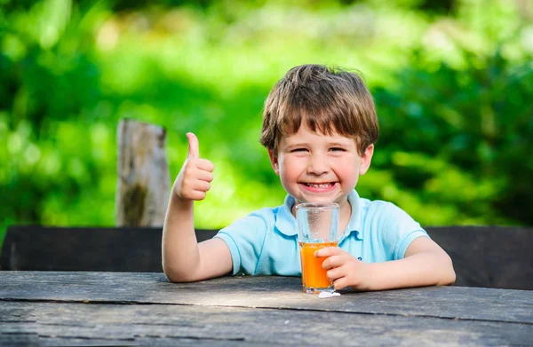 Yang pequeño y lindo chico en la foto con un vaso de jugo — Foto de Stock