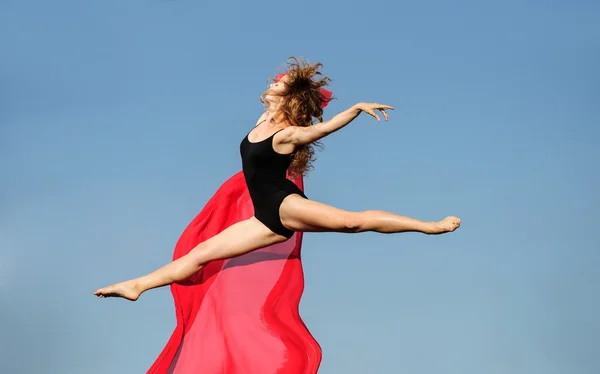 Επαγγελματική μπαλέτου χορευτής άλμα με κόκκινο ύφασμα στο ηλιοβασίλεμα ήλιο — Φωτογραφία Αρχείου