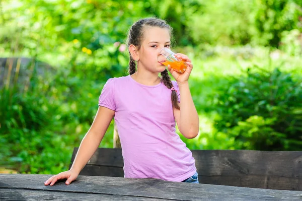 Yang ganska Europeiska flicka poserar med glas apelsinjuice — Stockfoto