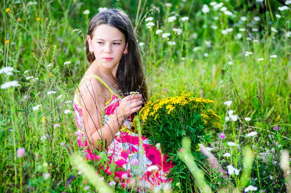 Portrait of school girl among the flowers in summer time — Stock Photo, Image