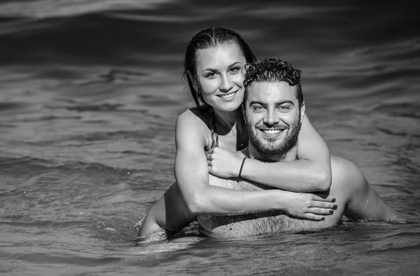 Black and white portrait of European couple hugging in the sea — Stock Photo, Image