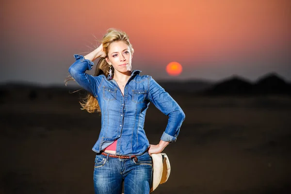 Retrato de una hermosa chica de campo frente al atardecer rojo — Foto de Stock