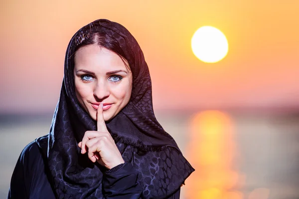 Vrouwen gekleed Midden-Oosten manier houdingen op zonsondergang achtergrond — Stockfoto