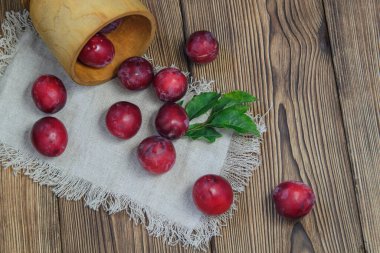 Büyük olgun erikler ters dönmüş bir sepetten masanın üzerindeki peçeteye döküldü.