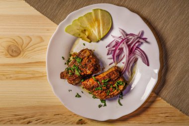 Baharatlı ızgara pirzola tabakta. Lezzetli bbq eti. Üst manzara, düz uzanma