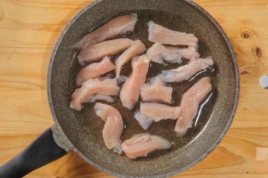 Çiğ tavuklu turtalar tahta bir tahtanın üstünde, üst tarafta.