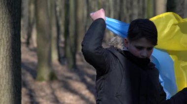 Ukrayna için dua et. Ukrayna bayrağı taşıyan bir çocuk. Ulusal bayrak sallayan küçük çocuk barış için dua ediyor. Bağımsızlık Günü 'nü kutlayan mutlu çocuk.