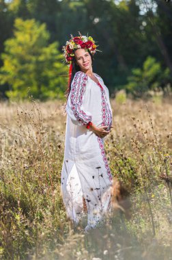 Güzel hamile Ukraynalı kadının açık hava portresi.