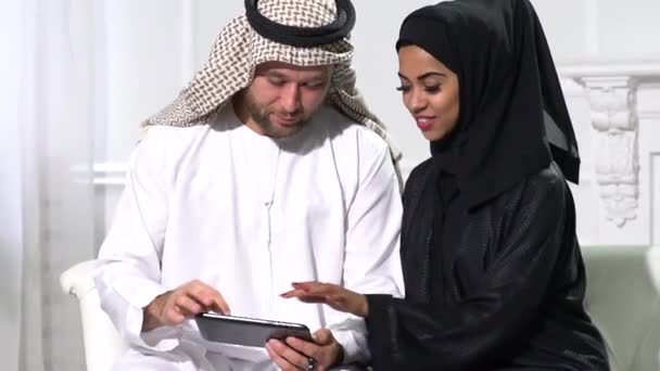 Arab Couple Home Sitting Raditional Dress Using Mobile Phone — Stockvideo