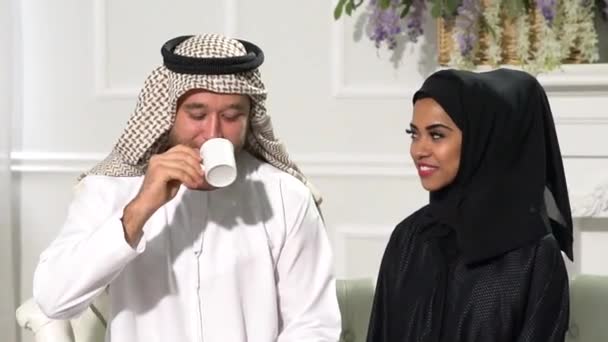 Αραβικό Ζευγάρι Στο Σπίτι Κάθεται Στο Ακτινωτό Φόρεμα Ποτό Καφέ — Αρχείο Βίντεο