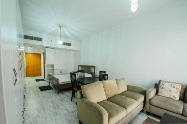 Cozy studio apartment design with bedroom and living space. Hotel room panoramic window, double bed, sofa and coffee table. Urban apartment concept