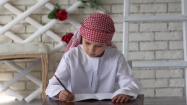 Küçük çocuk okulda okuyor, yazıyor..