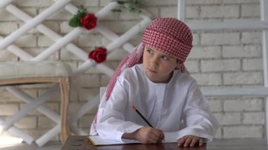Küçük çocuk okulda okuyor, yazıyor..