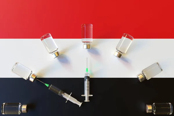 Glass vials and syringes on the flag of Yemen. Vaccination related conceptual 3D rendering — Stock Photo, Image