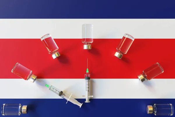 Spuiten en medische flacons op de vlag van Costa Rica. Conceptuele 3D-rendering met betrekking tot vaccinatie — Stockfoto