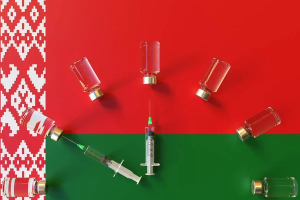 Шприцы и медицинские флаконы на флаге Беларуси. Концептуальный 3D рендеринг вакцинации — стоковое фото