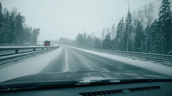 POV car shot in winter. Driving along empty forest highway in Moscow Region, Russia lizenzfreie Stockbilder