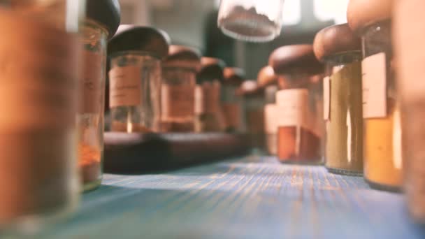 Lägga flaska med muskot på bordet bland andra kryddor — Stockvideo