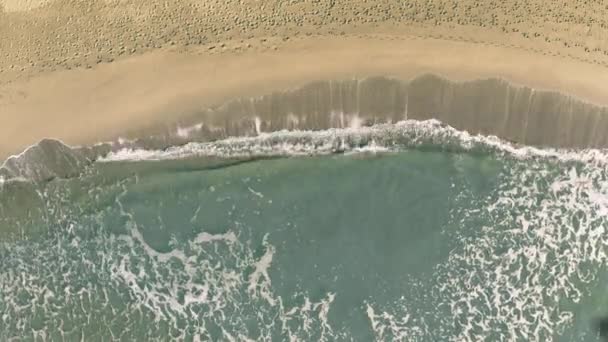 Stín létajícího letadla odhaluje text Malagy na písečné pláži — Stock video