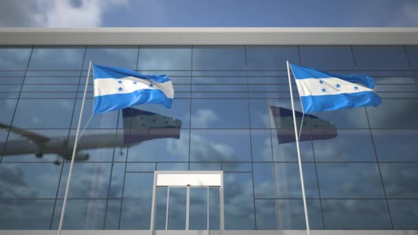 Havaalanı terminaline iniş yapan uçak ve Honduras bayrakları. — Stok video