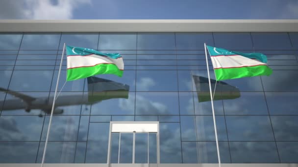 Přistávací letadlo a vlajky Uzbekistánu v letištním terminálu — Stock video