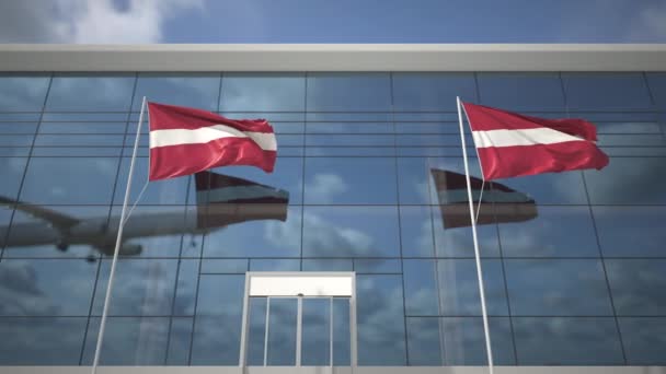 Bandiere sventolanti della Lettonia in aeroporto e l'atterraggio aereo — Video Stock