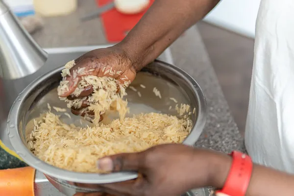 Афроамериканка из Нигерии моет рис перед готовкой — стоковое фото