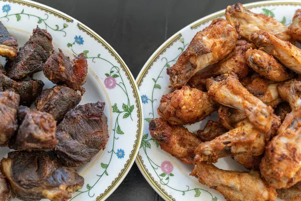 Grilled beef and chicken wings served together on table — Foto Stock