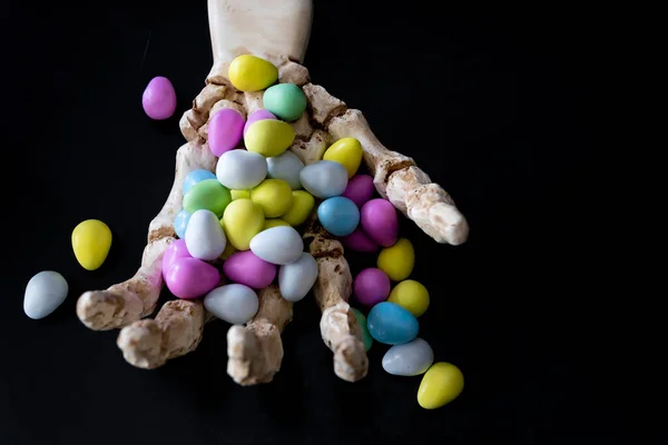 Mãos de esqueleto e garras segurando Halloween Candy — Fotografia de Stock