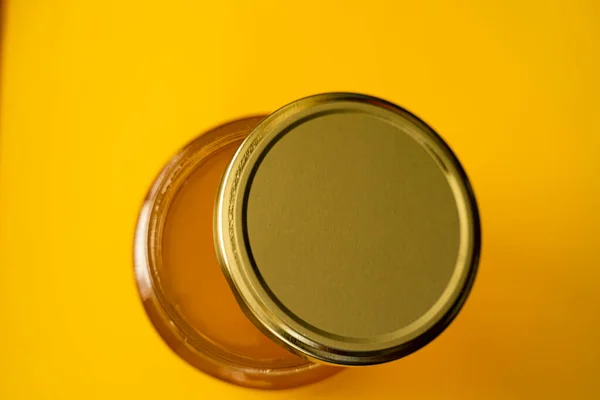 Potje biologische honing op gele achtergrond — Stockfoto