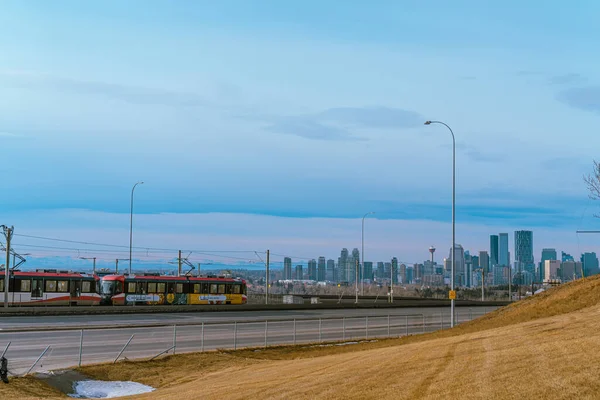 29 января 2022 - Calgary Alberta Canada -Calgary Transit LRT train with Calgary Skyline in background — стоковое фото