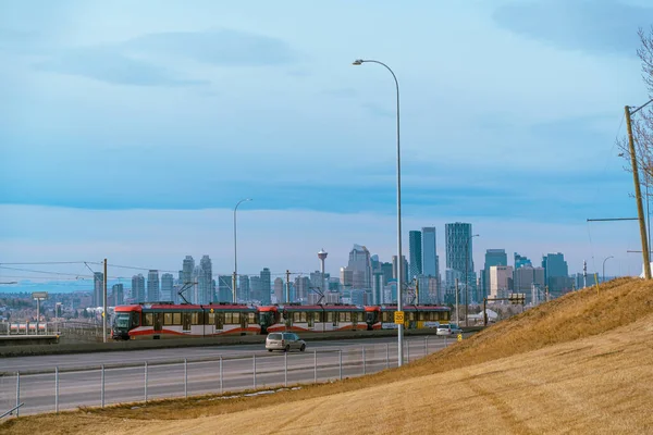 29. Januar 2022 - Calgary Alberta Kanada -Calgary Transit Stadtbahn mit Calgary Skyline im Hintergrund — Stockfoto