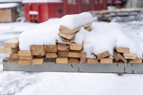Karla kaplı kereste yığını, nakliye sandığı yapmak için askıda. — Stok fotoğraf