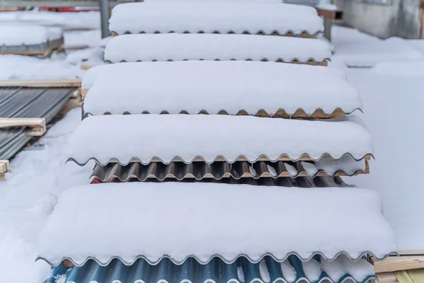 Stos blachy dachowej falistej ułożone na zewnątrz w śniegu — Zdjęcie stockowe