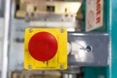 Bir fabrika makinesinin kırmızı acil durum durdurma düğmesi