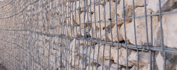 Rock and stone decorative background under wire cage — Photo