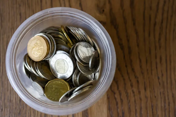 Pile of coins in a tip jar on a table — Stockfoto
