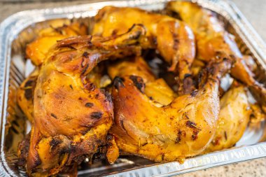 Bir tepsi ızgara tavuk butları yenmeye hazır.