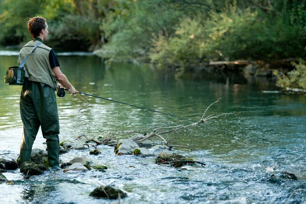 Bir balıkçı bir nehir üzerinde balıkçılık — Stok fotoğraf