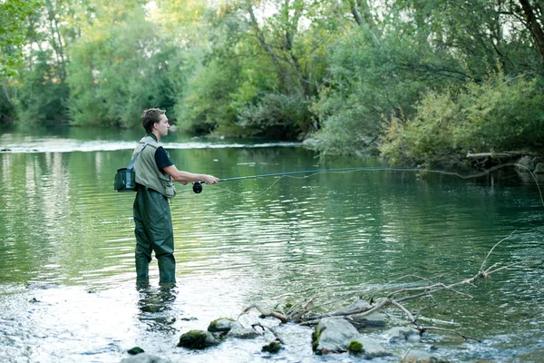 Un pescatore che pesca su un fiume — Foto Stock