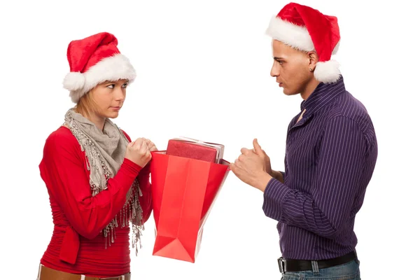 Meisje en man met KERSTMUTS vechten voor een cadeau — Stockfoto