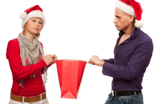 Girl and man with santa hat fighting for a present — Stock Photo, Image