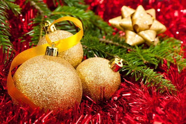 Weihnachtsschmuck - goldene Kugeln mit glänzendem Band im Hintergrund — Stockfoto