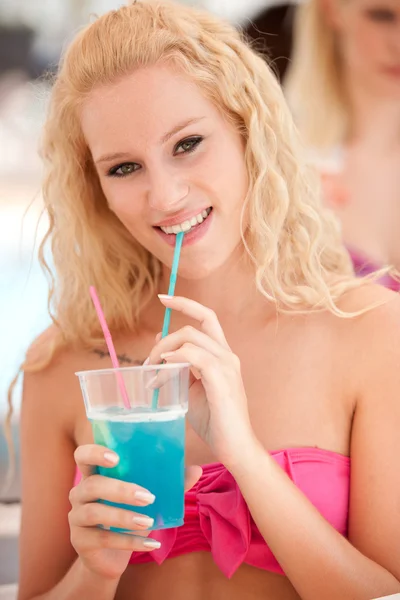 Jolie fille blonde boit cocktail bleu dans l'ombre un après-midi d'été chaud — Photo