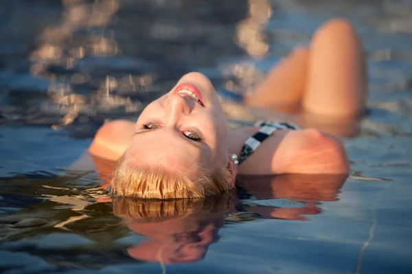 Attraktives blondes Mädchen in Bikini-Badebekleidung im Schwimmbad an einem Spätsommernachmittag — Stockfoto