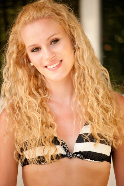 Attractive blonde in bikini swimwear rests on a beach — Stock Photo, Image