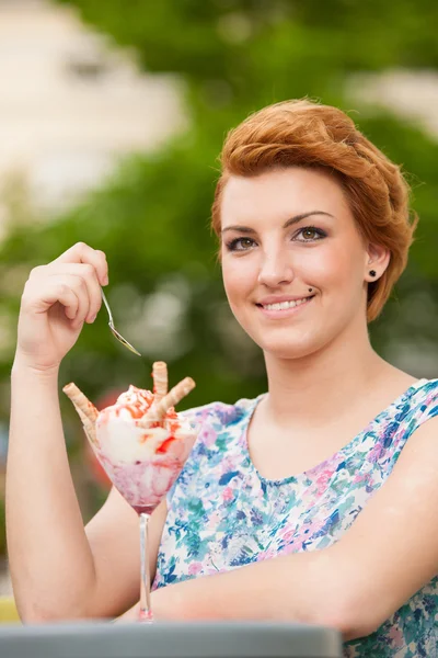 Attractive young woman eats ice cream outdoors — Stock Photo, Image