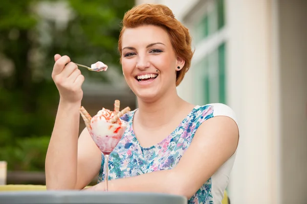 Attractive young woman eats ice cream outdoors — Stock Photo, Image