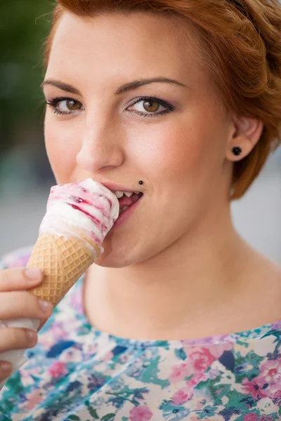 Attractive young woman eats ice cream outdoors — Stock Photo, Image