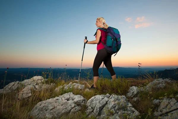 Yürüyüşe çıkmış bir kadın, dağlarda yürüyüş yapan güzel bir sarışın kız. — Stok fotoğraf